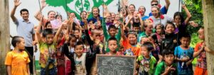 Group of children cheering outside classroom in Laos